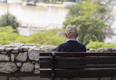Senior citizen sitting along on park bench.