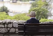 Senior citizen sitting along on park bench.