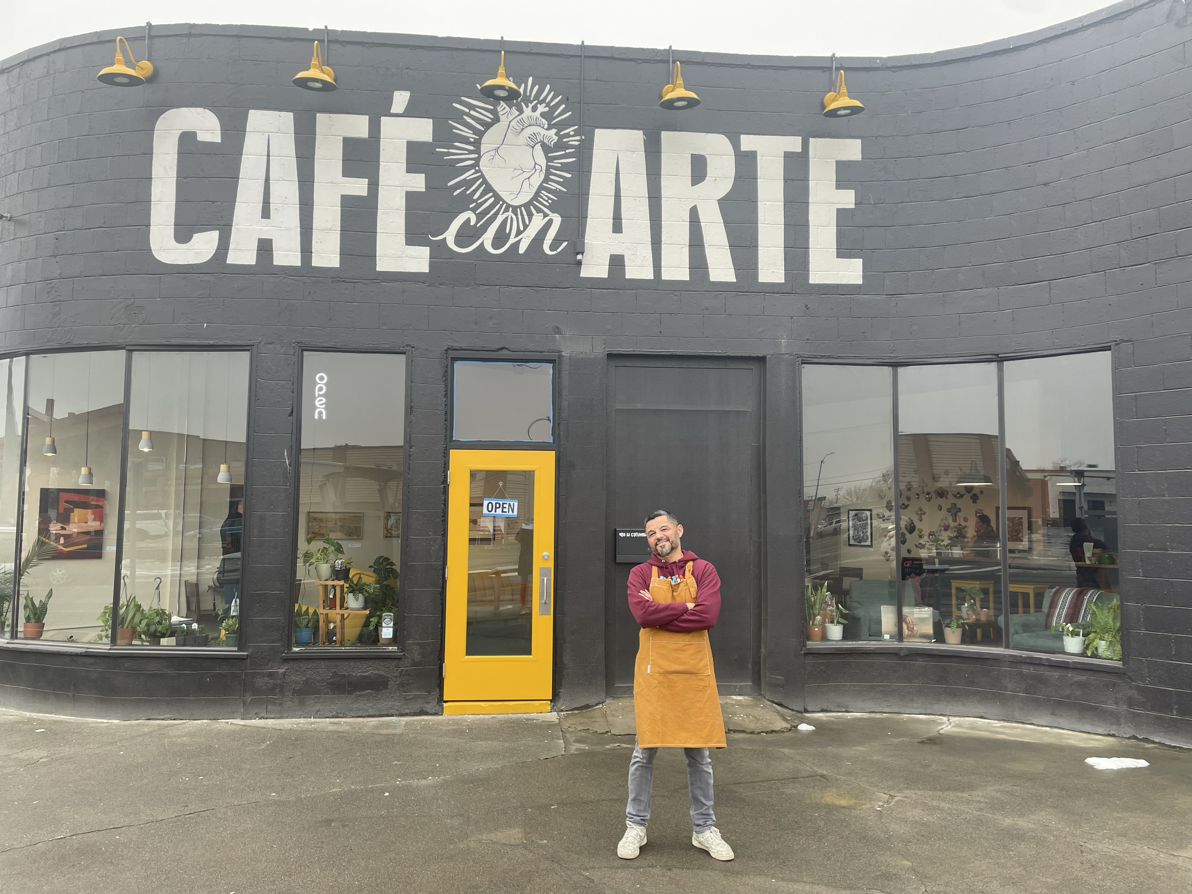 Cafe con Arte exterior with owner Saul Martinez in foreground.