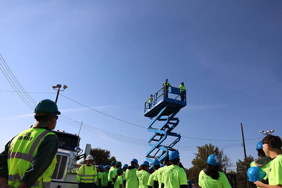 Students riding scissor lift