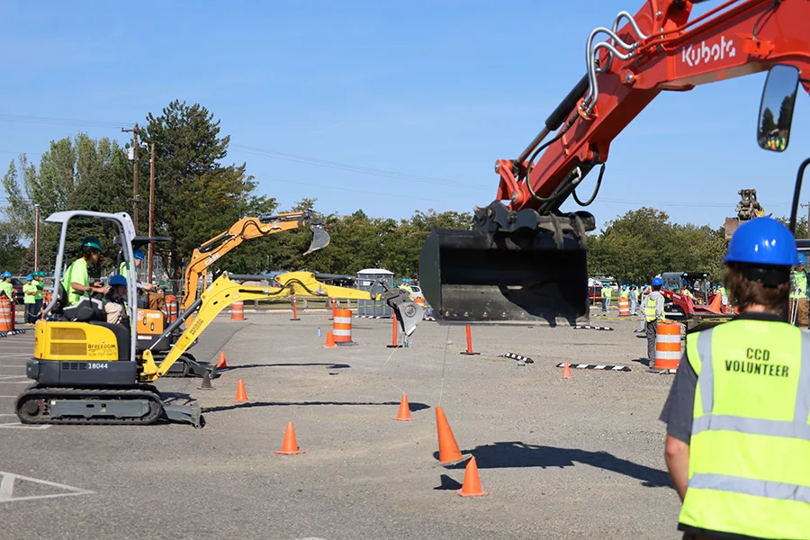 Students picking up cones with diggers