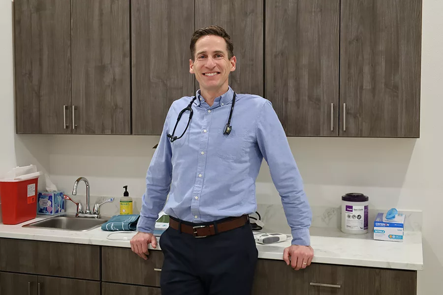 Stephen Smiley leaning against counter inside a doctor's office.