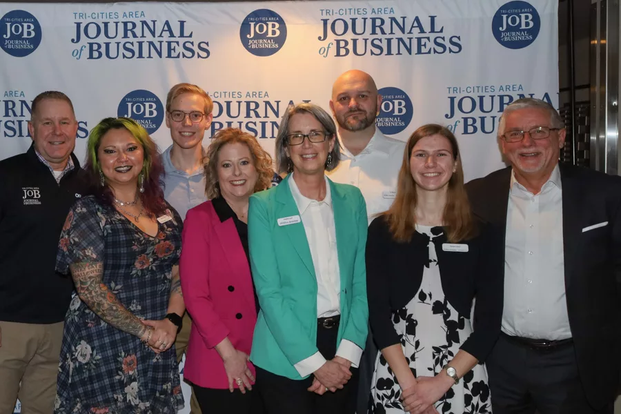 Tri-Cities Journal of Business team posing in-front of a JOB backdrop.