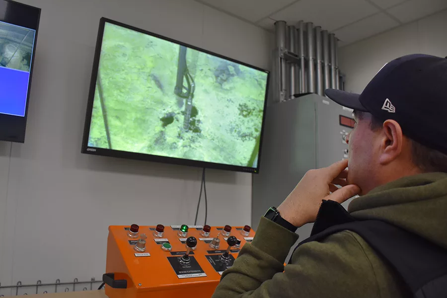 Worker viewing a monitor with a control panel.
