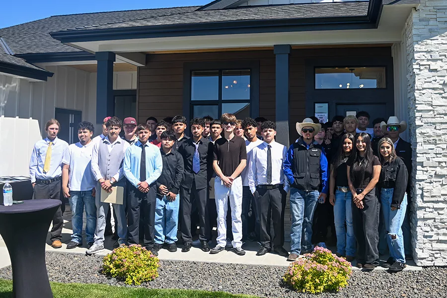 A group of students standing in front of a house.