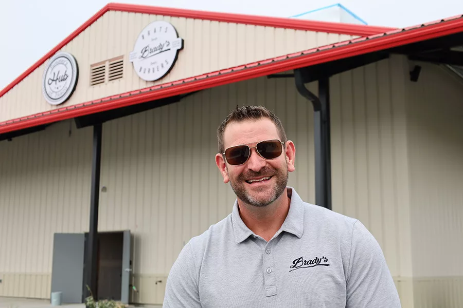 A man standing next to the new Summer's Hub.