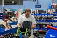 A man working on a small wheelchair.