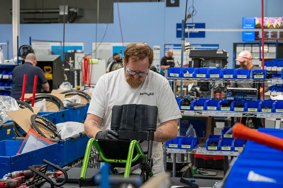 A man working on a small wheelchair.