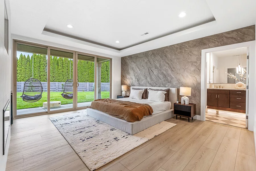 A bedroom with a sliding glass door to a backyard.