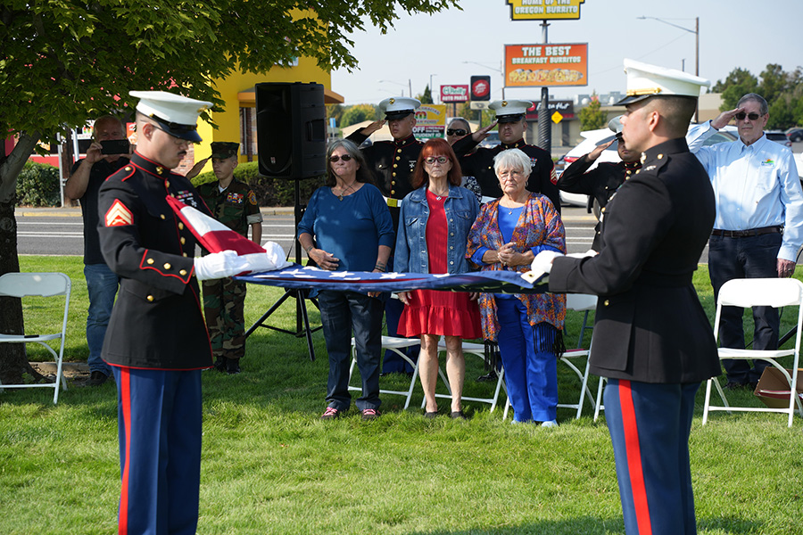 Service members holding an American flag.