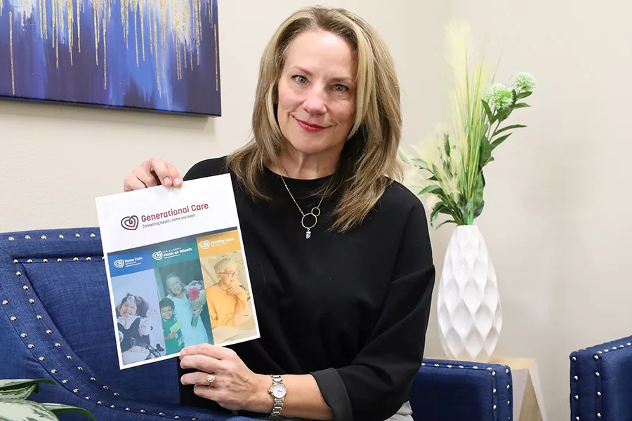 Woman holds paper that reads, "Generational Care".