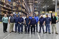 A group photo in a warehouse.