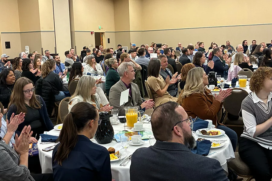 A crowd of people sitting at tables.