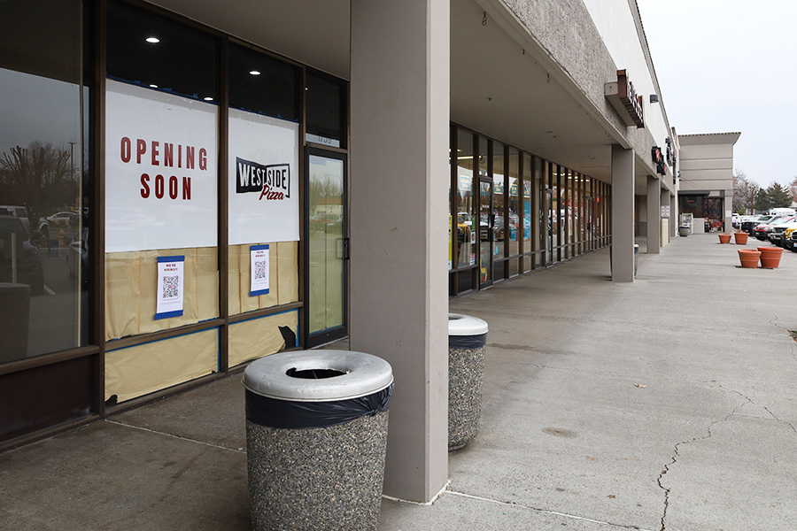 Part of a strip mall with a sign that says "Opening Soon Westside Pizza".