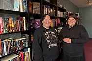 Two people standing in a book store.