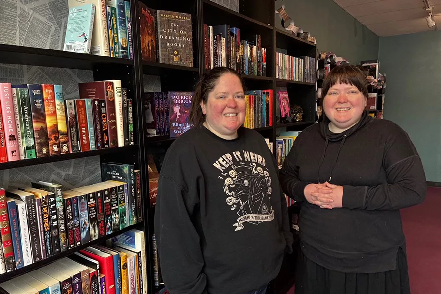 Two people standing in a book store.