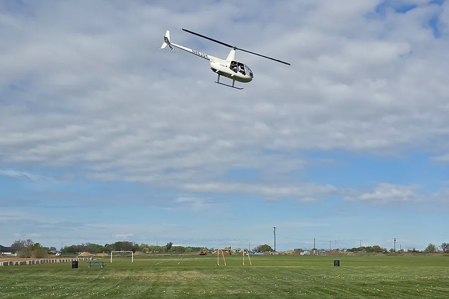 Helicopter flying over a field.