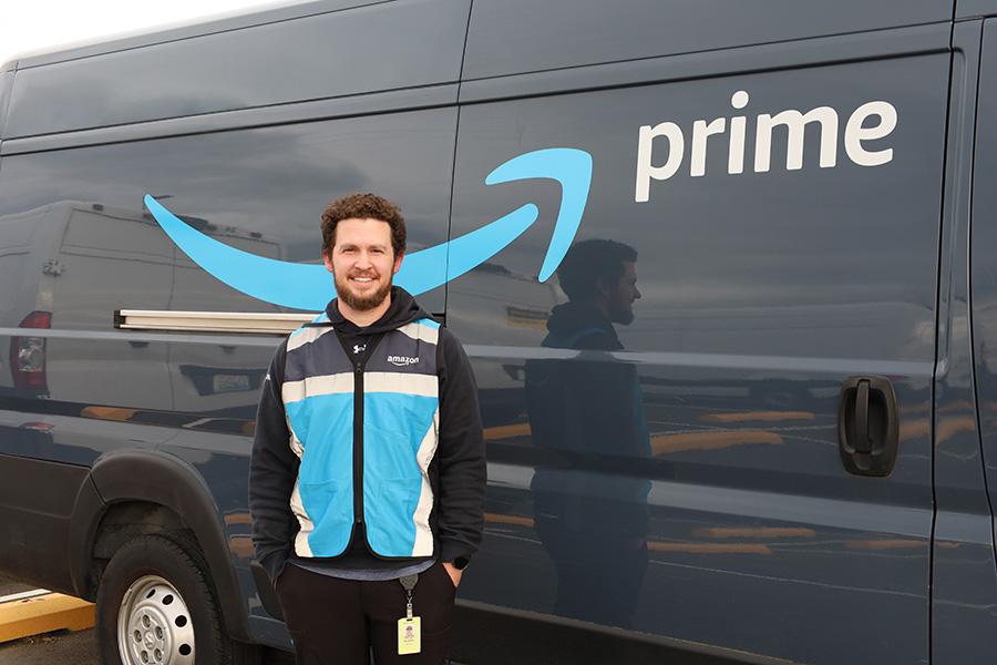 Man stands next to amazon truck.