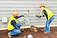 Workers installing a gas meter.