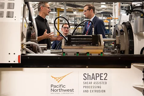 Two people talking near a machine.