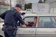 Police officer shaking someone's hand.