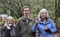 Twanoh- Hikers standing with Ranger Lewis showing their First Day Hike Buttons.jpeg