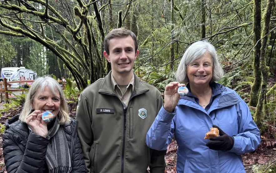 Twanoh- Hikers standing with Ranger Lewis showing their First Day Hike Buttons.jpeg