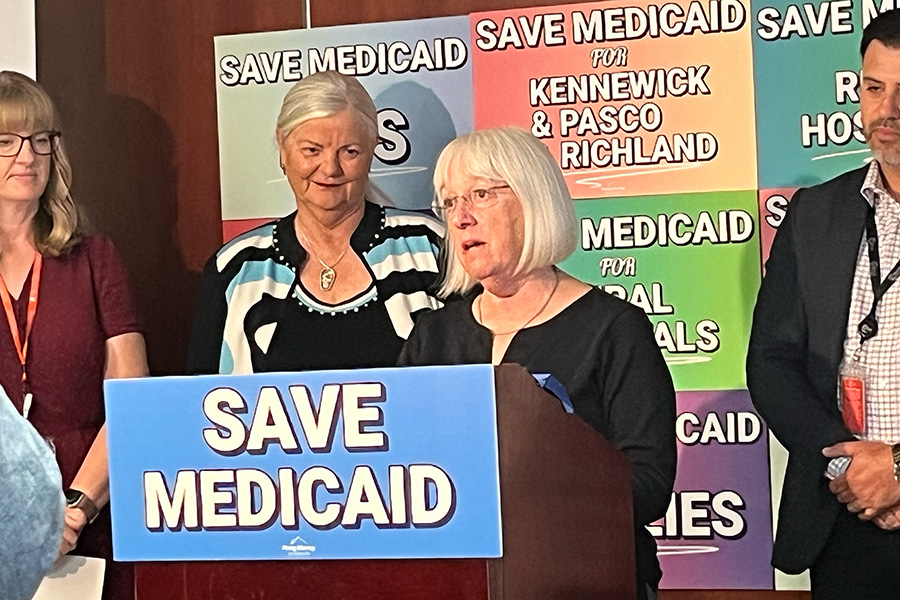 Patty Murray behind a podium that reads, "Save Medicaid".