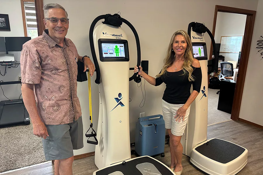 Two people standing next to person-height machines that resemble scales.