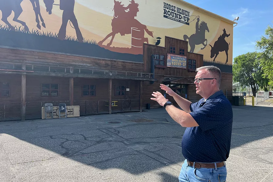 A man showing the exterior of the fairgrounds arena.