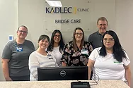 A group photo in front of a Kadlec sign.