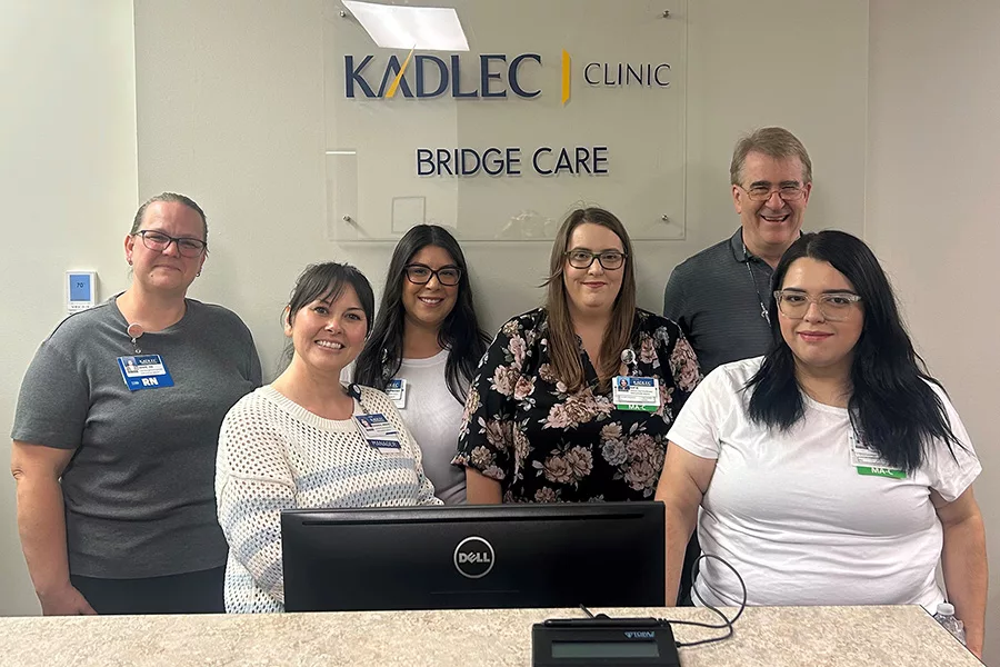 A group photo in front of a Kadlec sign.