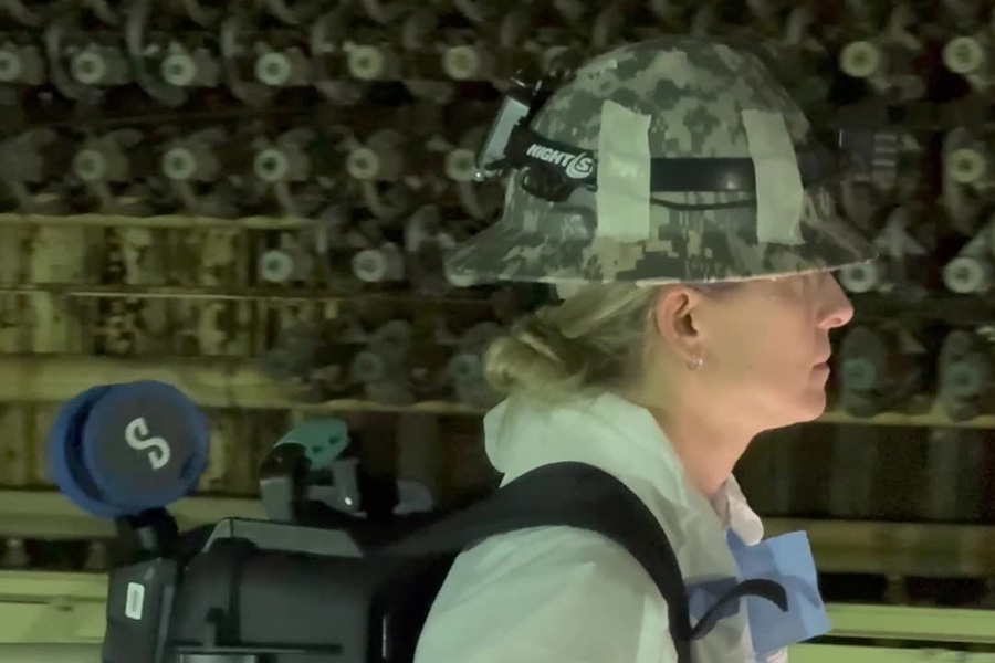 Woman with a hardhat and backpack.