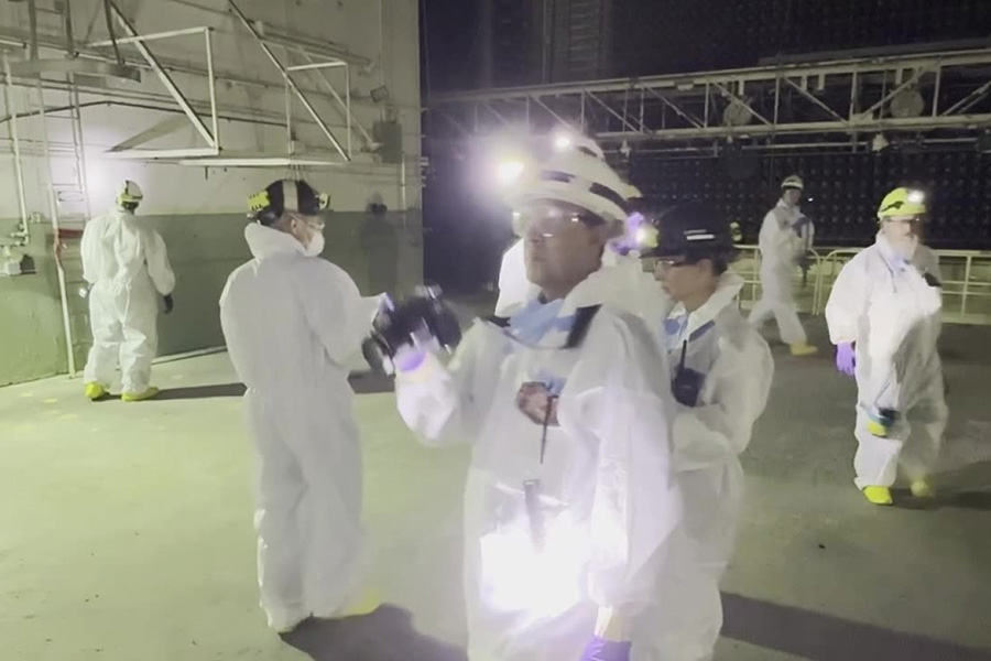 Multiple people with hazard suits, lights and hard hats.