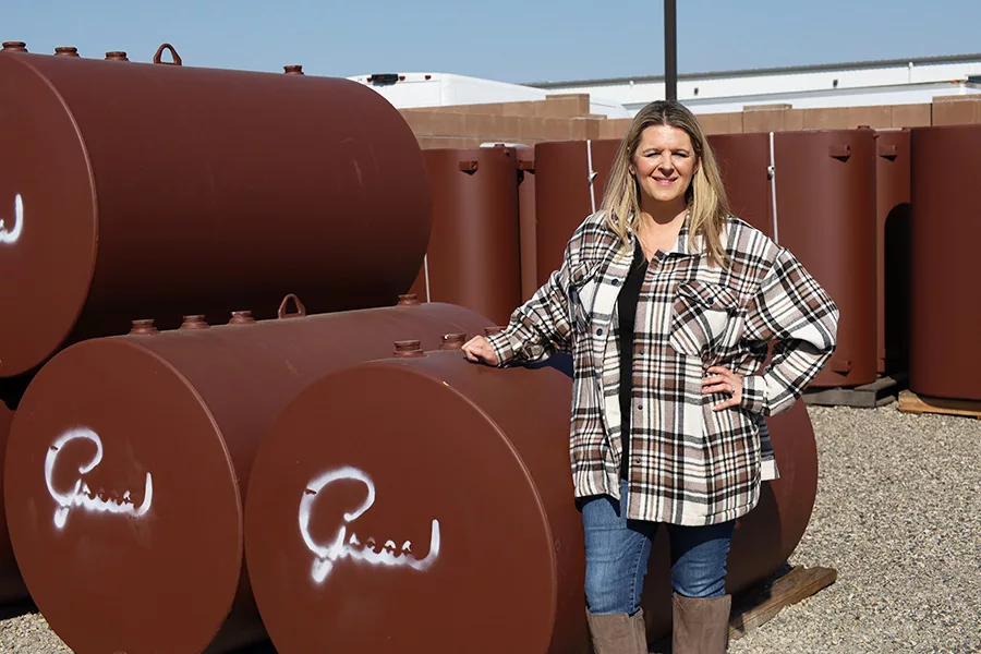 Woman standing next to brown tanks.