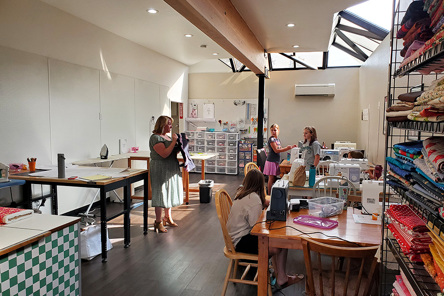 A woman showing young students some fabric.