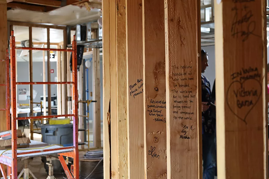 Exposed studs with positive messages. One reads, "bless this place with peace".