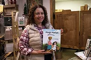 Woman holding a children's book.