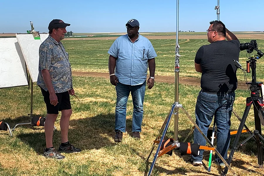 People in a field with film equipment.
