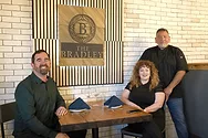 People sitting at a table near a sign that says, The Bradley.