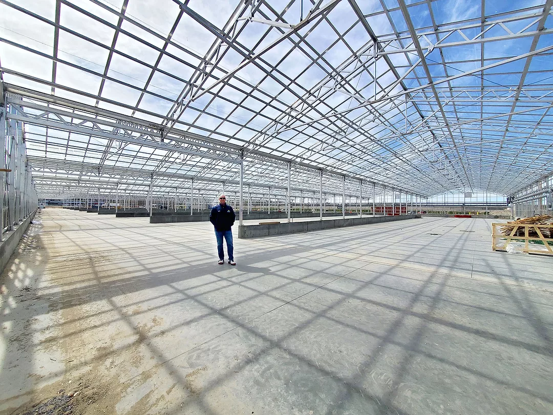 Man standing in greenhouse.