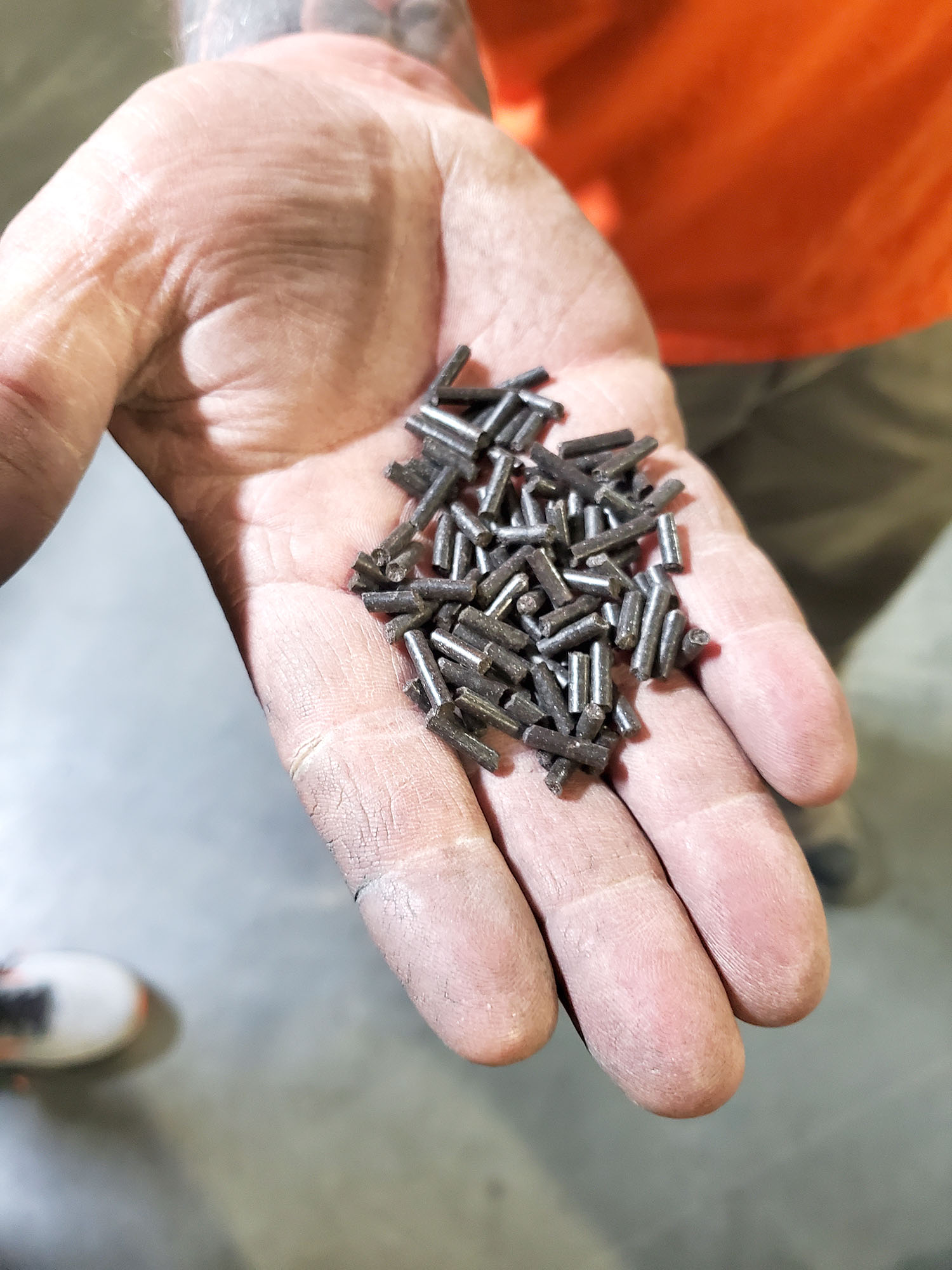Person holding black pellets.