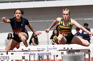 Girls jumping over hurdles.