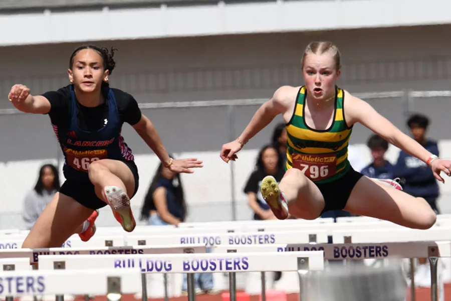 Girls jumping over hurdles.