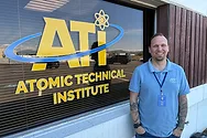 Man standing next to window that says "ATI Atomic Technical Institute".