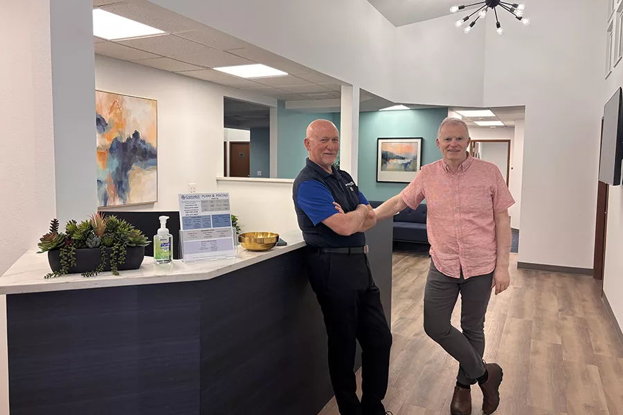 Two men standing in an office.