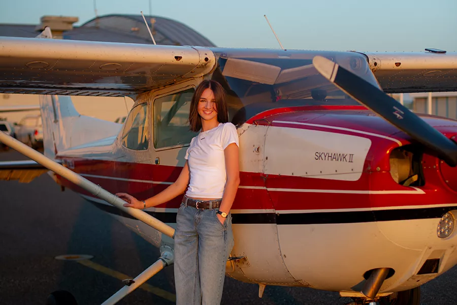 Woman standing by a plane.