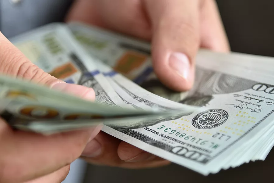 Someone counting $100 bills.