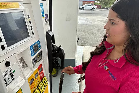 Woman at a gas pump.