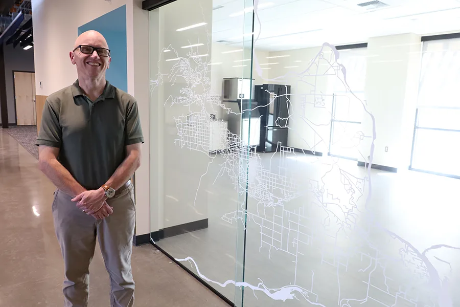 A man standing by a glass decal.